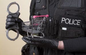 police holding handcuffs, shopping cart