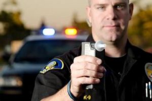 An officer with breathalyzer in Albuquerque testing a driver.