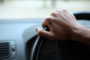 A person holding on the driving wheel.